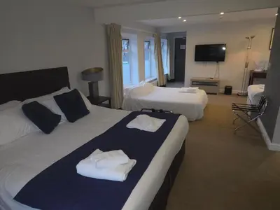 a hotel room with two beds and a flat screen tv at The Springfield Hotel in Fairbourne