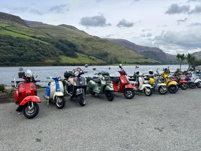 a row of motorcycles parked next to a body of water at The Springfield Hotel in Fairbourne