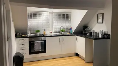 a kitchen with white cabinets and a sink and a window at Apartment Sleeps 2 with Wi-Fi in Ludlow