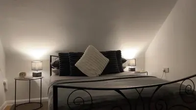 a bedroom with a bed with two lamps on it at Apartment Sleeps 2 with Wi-Fi in Ludlow