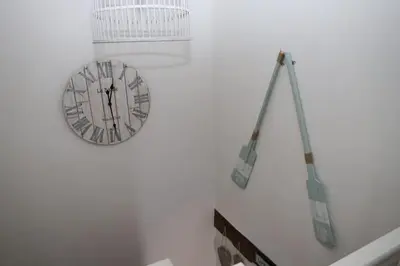 a clock hanging on a wall with a crane at Hen Blas, 14th century 2 bedroom Cottage in Barmouth