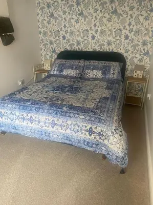a bedroom with a bed with a blue comforter at Hen Blas, 14th century 2 bedroom Cottage in Barmouth