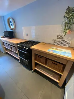 a kitchen with a stove and a wooden counter at Hen Blas, 14th century 2 bedroom Cottage in Barmouth