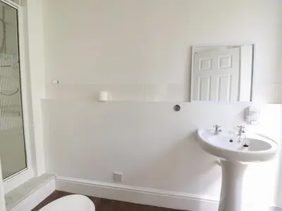 a white bathroom with a sink and a mirror at Serenity House, The Retreat in Llangammarch Wells