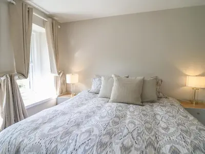 a bedroom with a large bed with pillows and a window at Serenity House, The Retreat in Llangammarch Wells