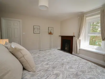 a bedroom with a bed and a fireplace at Serenity House, The Retreat in Llangammarch Wells
