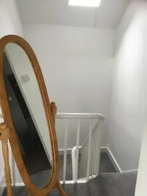 a mirror on a stand next to a staircase at Harbour House in Barmouth