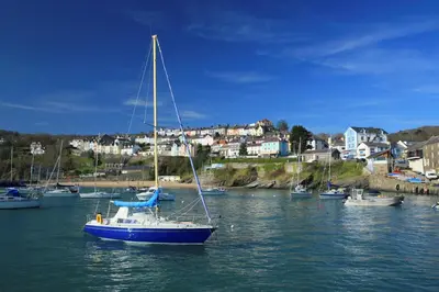 a sail boat in the water in a harbor at Nyth y Wennol Aberaeron in Llanarth
