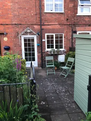 a patio with two chairs in front of a brick building at Simply Shrewsbury, by Severn Theatre & Quarry Park in Shrewsbury