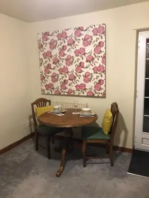 a dining room table with two chairs and a painting on the wall at Simply Shrewsbury, by Severn Theatre & Quarry Park in Shrewsbury
