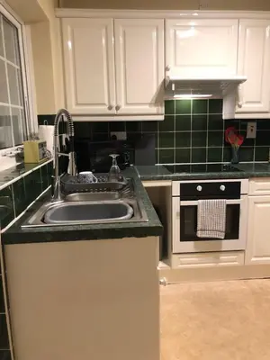 a kitchen with white cabinets and a sink at Simply Shrewsbury, by Severn Theatre & Quarry Park in Shrewsbury