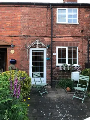 two chairs sitting outside of a brick house at Simply Shrewsbury, by Severn Theatre & Quarry Park in Shrewsbury