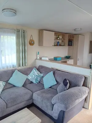 a living room with a couch with blue pillows at 2 Bed Chalet - Sleeps 4 - Pets - Parking in New Quay
