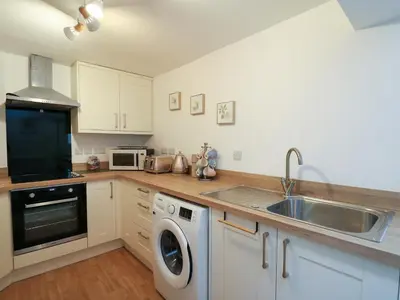 a kitchen with a sink and a washing machine at 1 Penporth in Rhayader