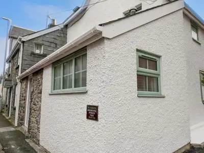a white house with a sign on the side of it at 1 Penporth in Rhayader