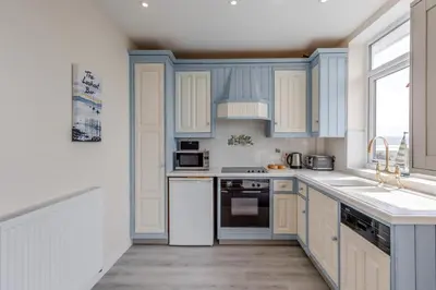 a kitchen with blue cabinets and white appliances at 3 Bed in Aberdovey oc-v29263 in Aberdyfi