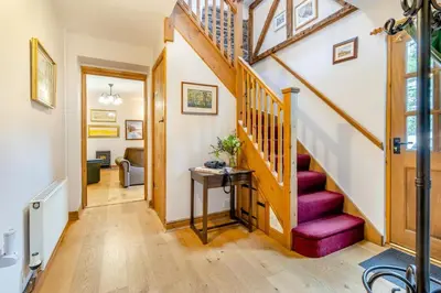 a hallway with a wooden staircase with purple cushions at 2 Bed in Knighton oc-t29330 in Felindre