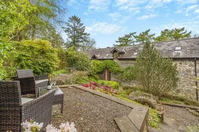 a garden with chairs and a stone house at 2 Bed in Knighton oc-t29330 in Felindre