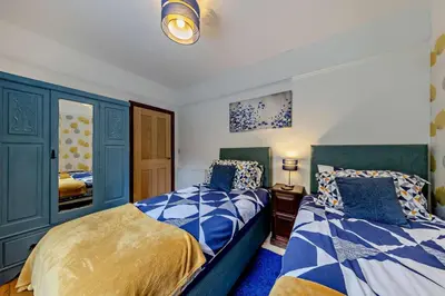 two beds in a bedroom with blue and white at 5 Bed in Bontddu oc-c29184 in Penmaenpool