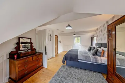 a bedroom with a king sized bed and a dresser at 5 Bed in Bontddu oc-c29184 in Penmaenpool