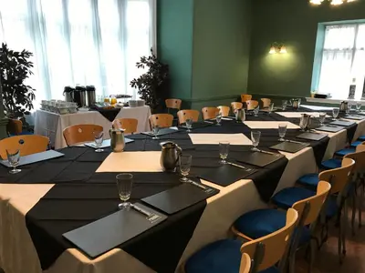 a row of tables and chairs in a room at The Hotel Commodore in Llandrindod Wells