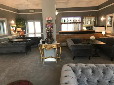 a living room with couches and a bar at The Hotel Commodore in Llandrindod Wells