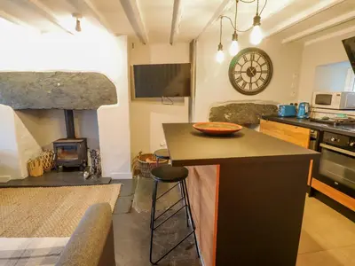 a kitchen with a counter and a stove with a fireplace at Ty Dyffryn in Blaenau-Ffestiniog