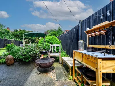 a garden with a wooden table and a piano at 3 Bedroom home within walking distance of town - Pass the Keys in Shrewsbury
