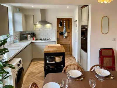 a kitchen with a table and chairs in a kitchen at 3 Bedroom home within walking distance of town - Pass the Keys in Shrewsbury