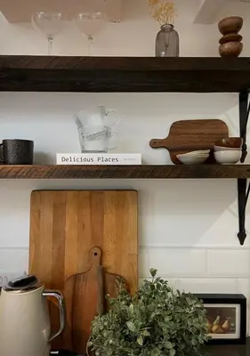 a kitchen shelf with a wooden cutting board and a plant at Poets Cottage Eglwys Fach in Scyborycoed
