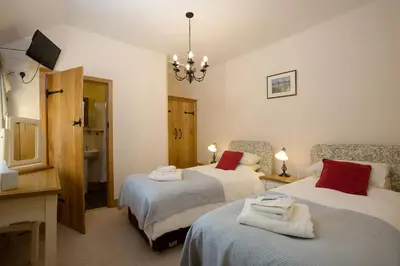 a bedroom with two beds with towels on them at The Manor House in Church Stretton