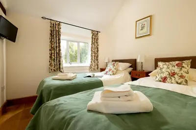 a room with two beds with towels on them at The Manor House in Church Stretton