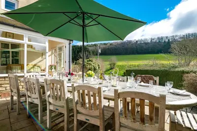 a table with a green umbrella on a patio at The Manor House in Church Stretton