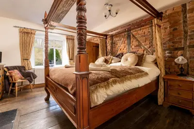 a bedroom with a large wooden bed in a room at The Manor House in Church Stretton