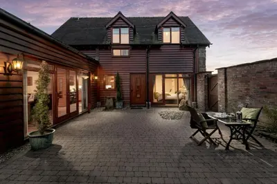 a house with a patio with chairs and a table at Toad Hall in Church Stretton