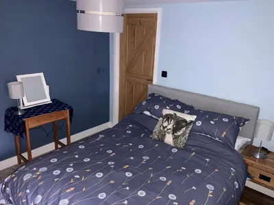 a bedroom with a bed with a dog pillow on it at Ty Bach Coch in Scethrog