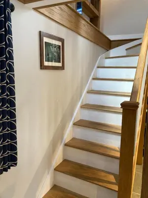 a staircase in a home with wood treads at Ty Bach Coch in Scethrog