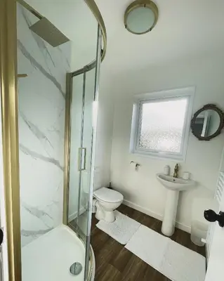 a bathroom with a shower and a toilet and a sink at Ty Ray Penmaes in Rhayader