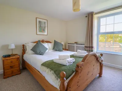a bedroom with a wooden bed with towels on it at Glasfryn in Dolgellau