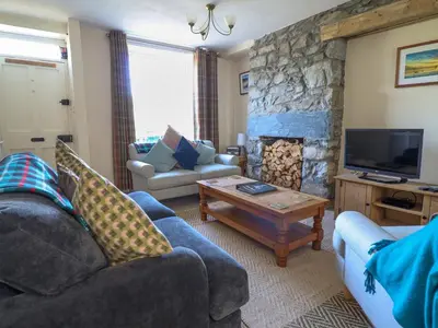 a living room with two couches and a stone fireplace at Glasfryn in Dolgellau