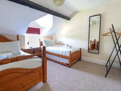 a bedroom with two beds and a mirror at Glasfryn in Dolgellau
