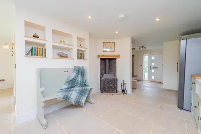 a living room with a fireplace and white walls at Mill Cottages Shrewsbury With Hottub in Merrington