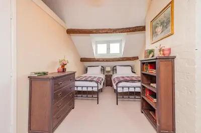 a attic bedroom with two beds and a dresser at Mill Cottages Shrewsbury With Hottub in Merrington
