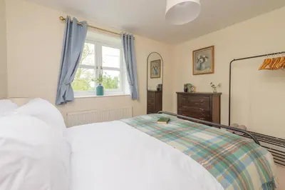 a bedroom with a white bed and a window at Mill Cottages Shrewsbury With Hottub in Merrington