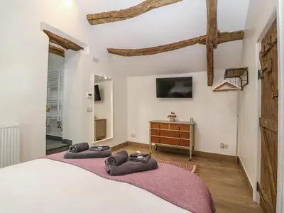 a bedroom with a large bed with towels on it at Y Stabl in Dyffryn