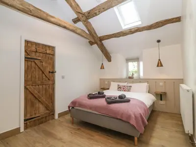 a bedroom with a bed and a barn door at Y Stabl in Dyffryn