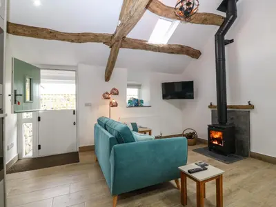 a living room with a blue couch and a fireplace at Y Stabl in Dyffryn