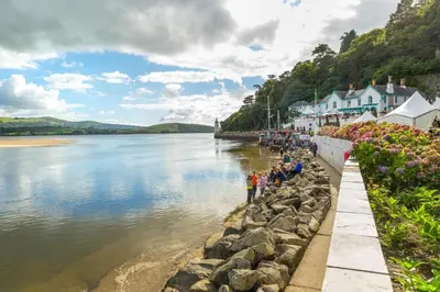 a group of people walking along the shore of a body of water at 3 Bed in Llanbedr oc-t28932 in Llanbedr