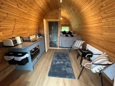 a kitchen and living room in a log cabin at The Pod Patch - Bryn Pod in Bishops Castle