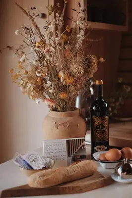 a table with a bottle of wine and a vase with flowers at Two unique cabins wrapped in beautiful welsh scenery in Presteigne
